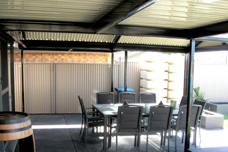 Outdoor entertaining area with verandah, plantar boxes and backyard.